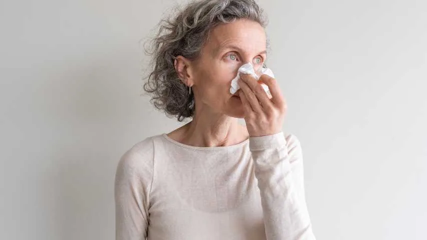 Person holding a tissue during an allergy flare.